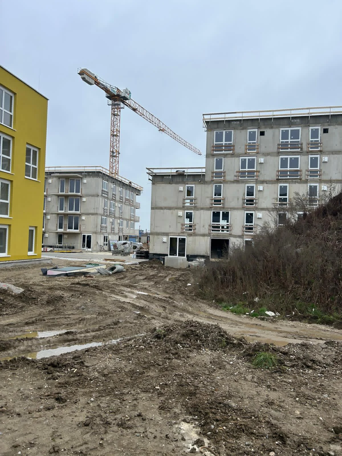 Baukran zwischen Gebäuden mit montierten Fenstern