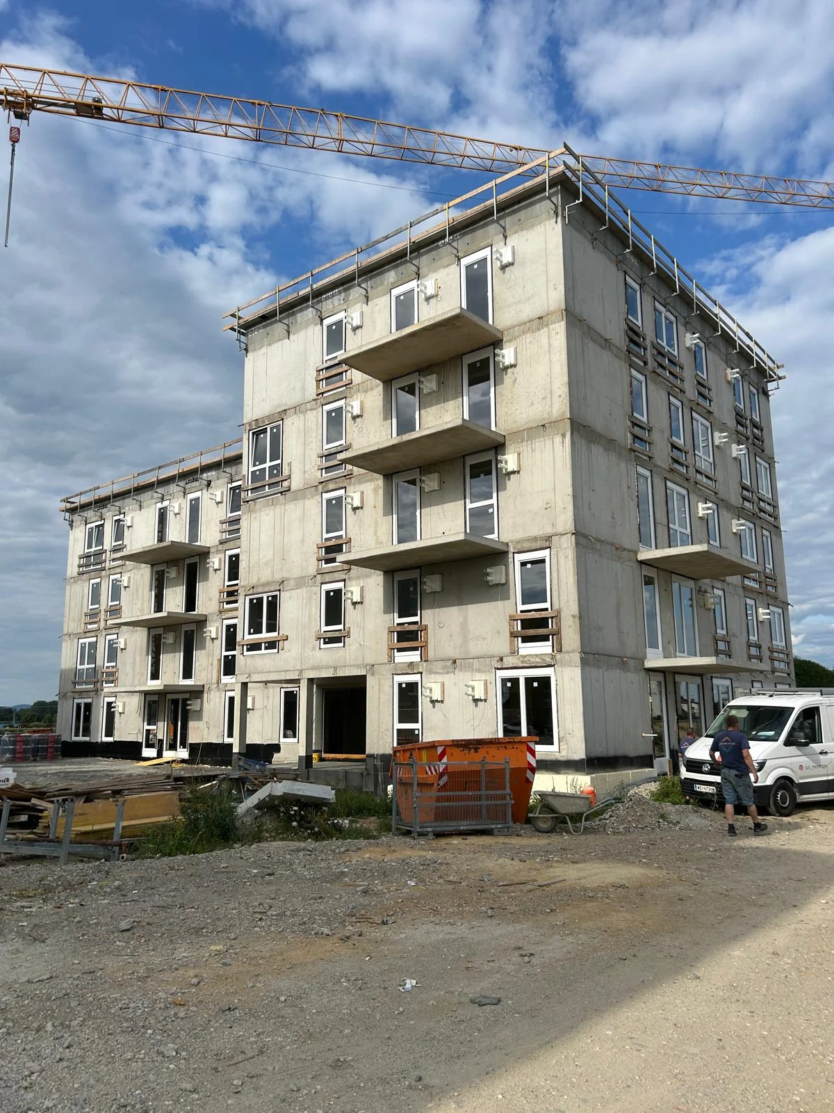Mehrgeschossiger Neubau mit montierten Fenstern und Balkonen
