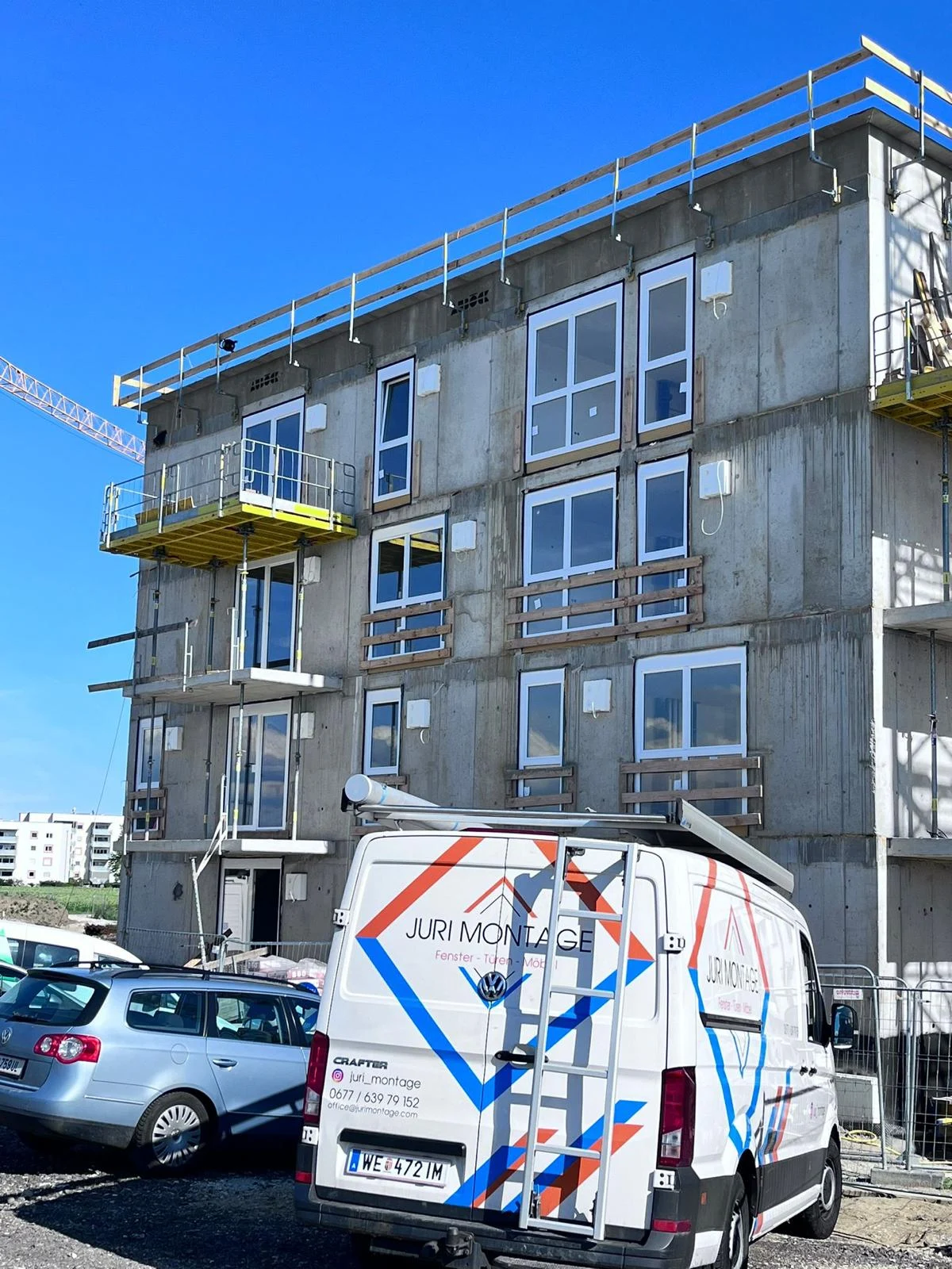 JURI MONTAGE Montagebus mit originaler orange-blauer Beklebung auf der Baustelle