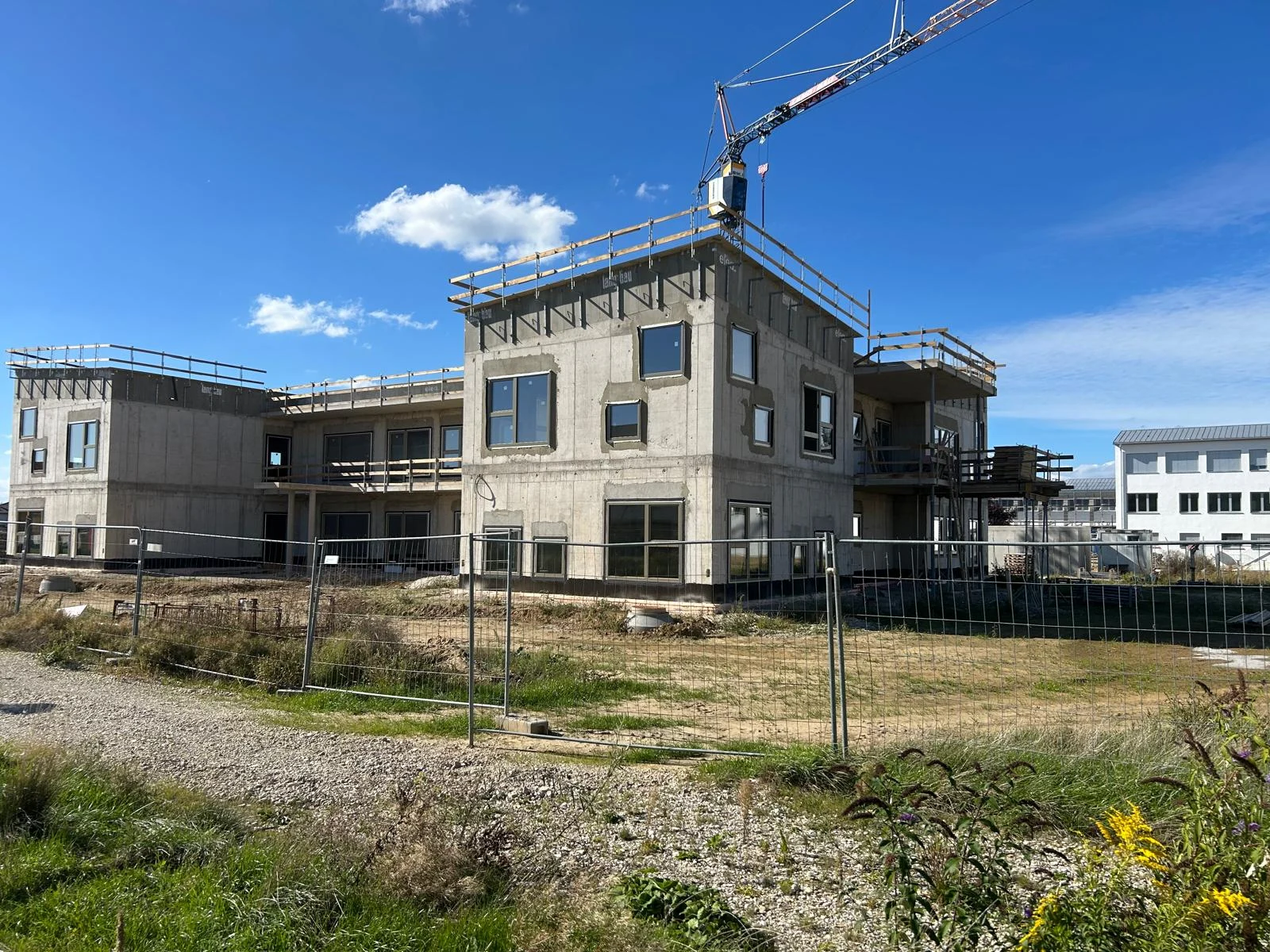 Neubau mit montierten Fenstern und Baukran